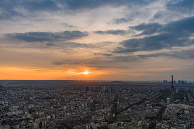 Aerial view of cityscape against cloudy sky during sunset