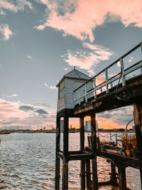 Pier over sea against sky during sunset