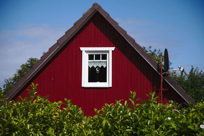 Red house and building against sky