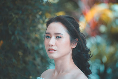 Portrait of young woman looking away outdoors