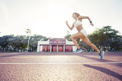 Determined female athlete running on race track