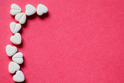 High angle view of heart shape on pink over colored background