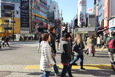 People walking on road along buildings