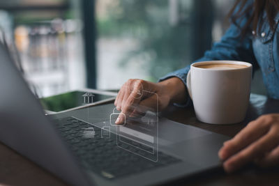 Midsection of woman using laptop on table