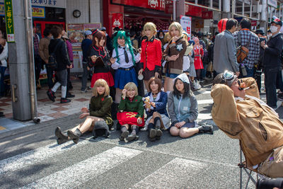 People sitting on street in city