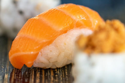 A selection of freshly made sushi rolls served on a blue ceramic plate landscape close up