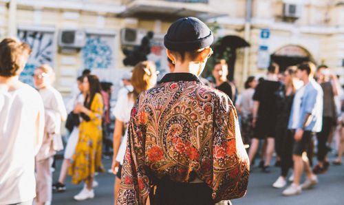 Rear view of people walking on street in city