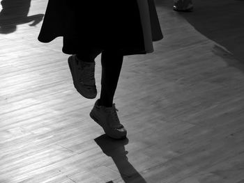 Low section of woman standing on hardwood floor