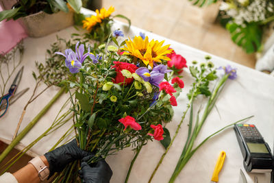 Low section of woman with flowers on table