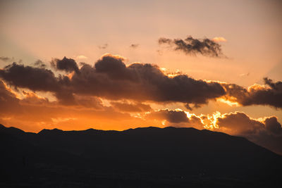 Scenic view of silhouette mountains against sky during sunset