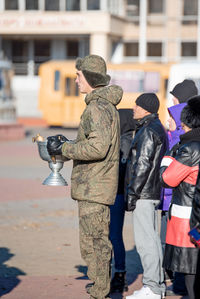 Rear view of people standing in city