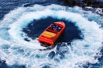 High angle view of sea waves splashing on boat