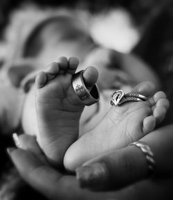 Cropped hand of mother holding baby wearing ring