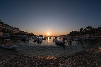 Boats in sea at sunset