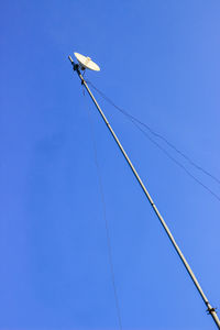 Low angle view of power line against clear blue sky