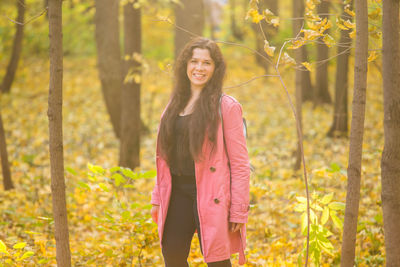 Happy woman standing by plants