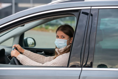 Portrait of woman seen through car window