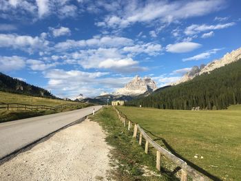 Road leading towards mountains against sky