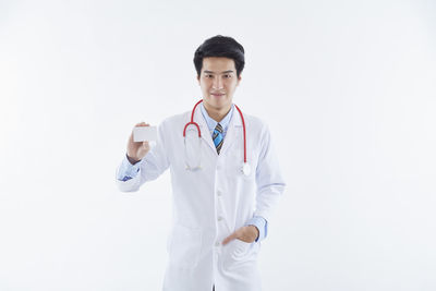 Portrait of teenage girl standing against white background