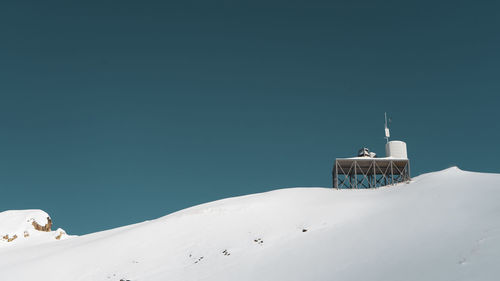 Snow covered mountain against clear blue sky