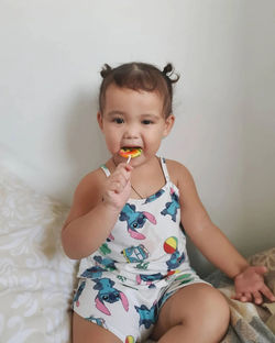 Portrait of cute girl playing with lollipop 