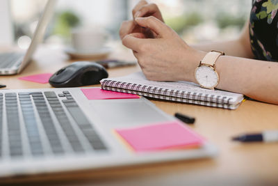 Midsection of man using mobile phone on table