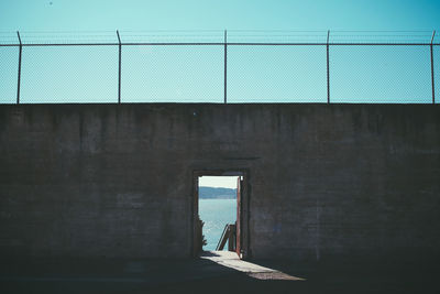 Sea seen through door amidst wall