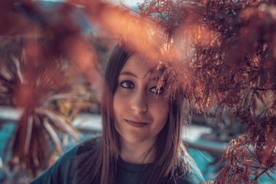 Woman looking at branches while standing outdoors