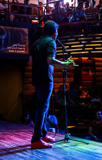 Rear view of man standing at music concert