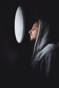 Man looking through window in darkroom