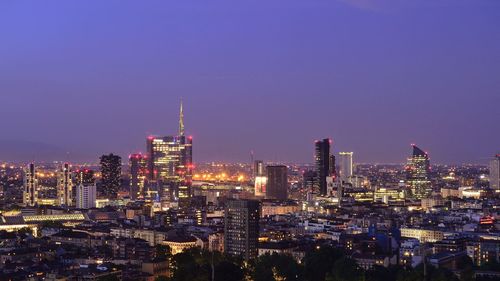 Illuminated cityscape against sky at night