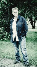 Portrait of smiling young woman standing against trees