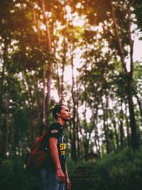 Side view of woman looking away in forest