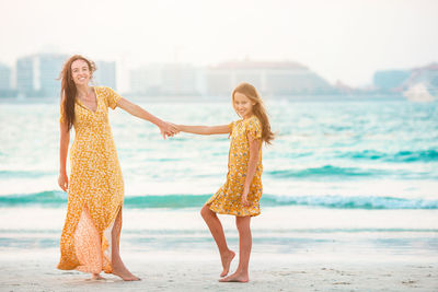 Woman with arms raised on beach