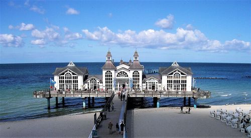 Built structure on beach by sea against sky