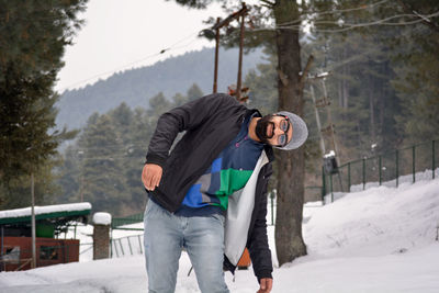 Portrait of young man standing on snow 