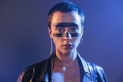 Portrait of young man wearing eyeglasses against black background