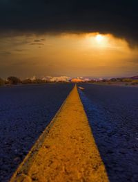 Surface level of road against sky during sunset