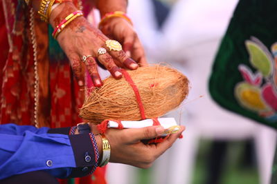 Close-up of hands holding cross against blurred background