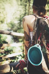 Rear view of woman with backpack standing in forest