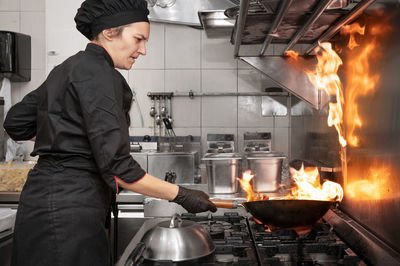 Side view of man preparing food in kitchen