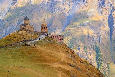 Gergeti trinity church or tsminda sameba on the hilltop with mount kazbek , georgia
