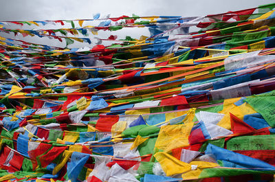 Low angle view of multi colored tibetan flags hanging against sky