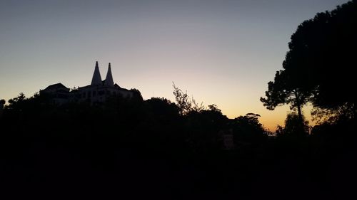 Low angle view of silhouette trees against sky at dusk
