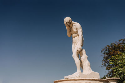 Low angle view of statue against blue sky