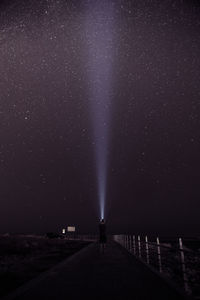 Scenic view of a man holding a torch against starry sky