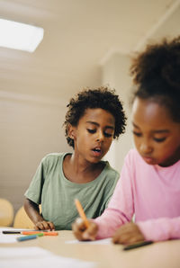 Schoolboys writing at desk in classroom