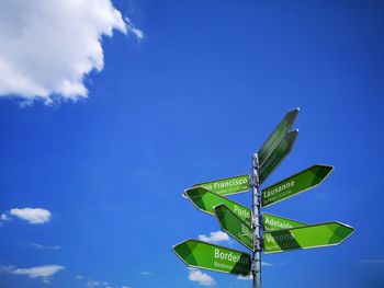 Low angle view of road sign against blue sky