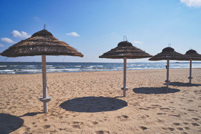 Umbrellas on beach against sky