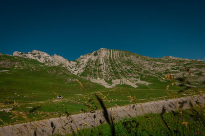 Scenic view of mountains against clear blue sky